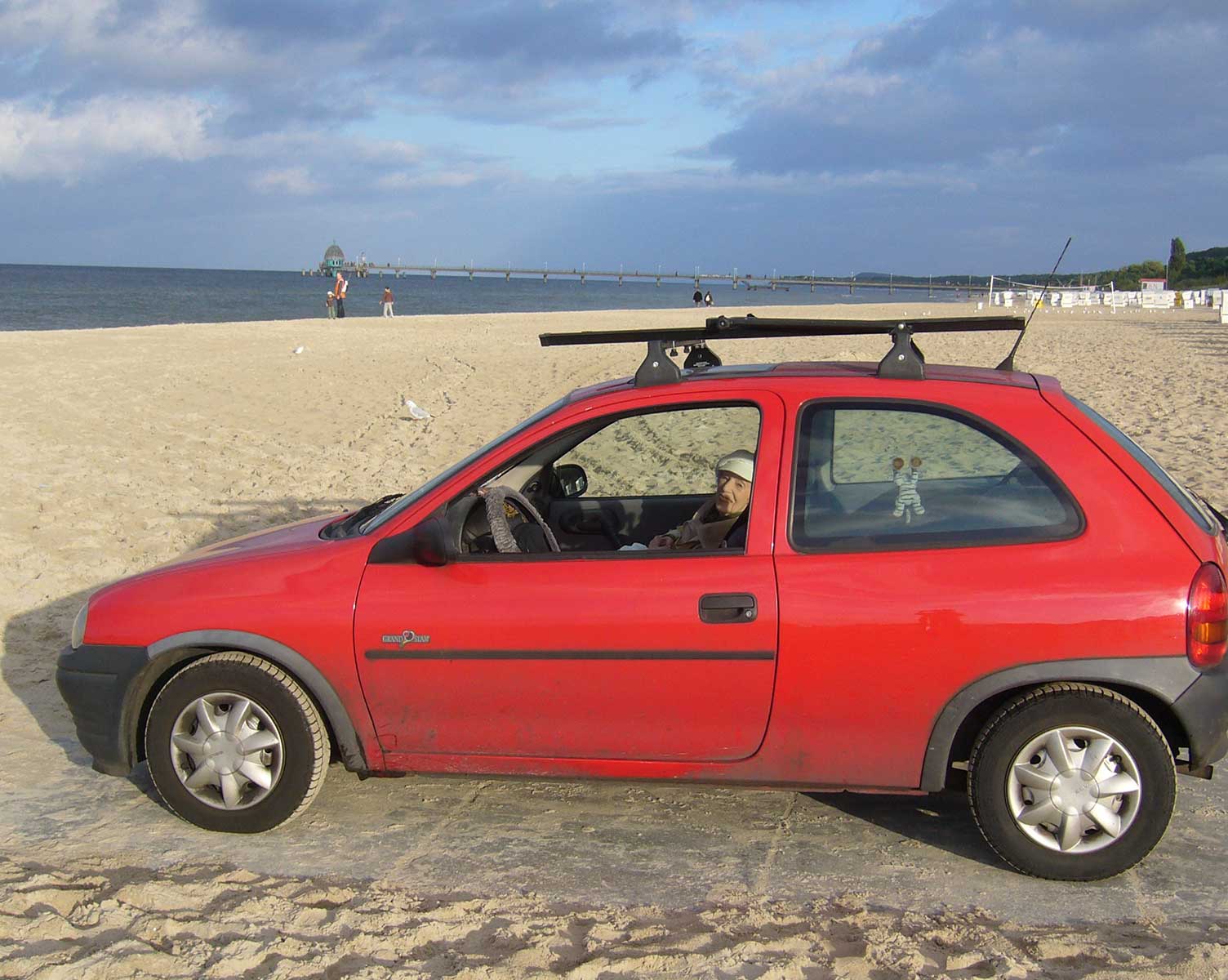 Rotes Auto am Strand an der Ostsee